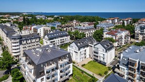 A residential area with modern apartment buildings, including balconies and solar panels.