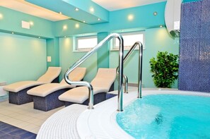 A spa area with a pool, lounge chairs, and a staircase leading to the pool. - Apartamenty Sun & Snow Casa Marina (Swinoujscie)