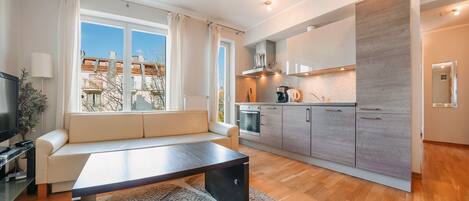 Eine moderne Wohnung mit Wohnbereich, Küche und Essplatz.