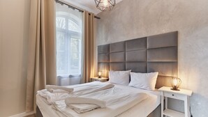 A modern bedroom with a large bed, two bedside tables, and a headboard. - Apartamenty Sun & Snow Promenada (Swinoujscie)