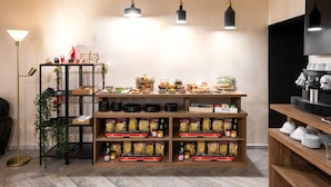 A kitchen area with a wooden counter displaying various food items and a shelf stocked with packaged goods. - Toledo Lifestyle (Naples)
