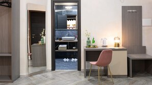A modern bathroom with a large mirror, a sink, and a vanity. There is a chair and a small table with a lamp. - Toledo Lifestyle (Naples)