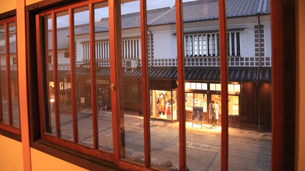 A traditional Japanese building with a wooden window frame and a view of the street outside. - Temari Hotel Yukikai (Kurashiki)