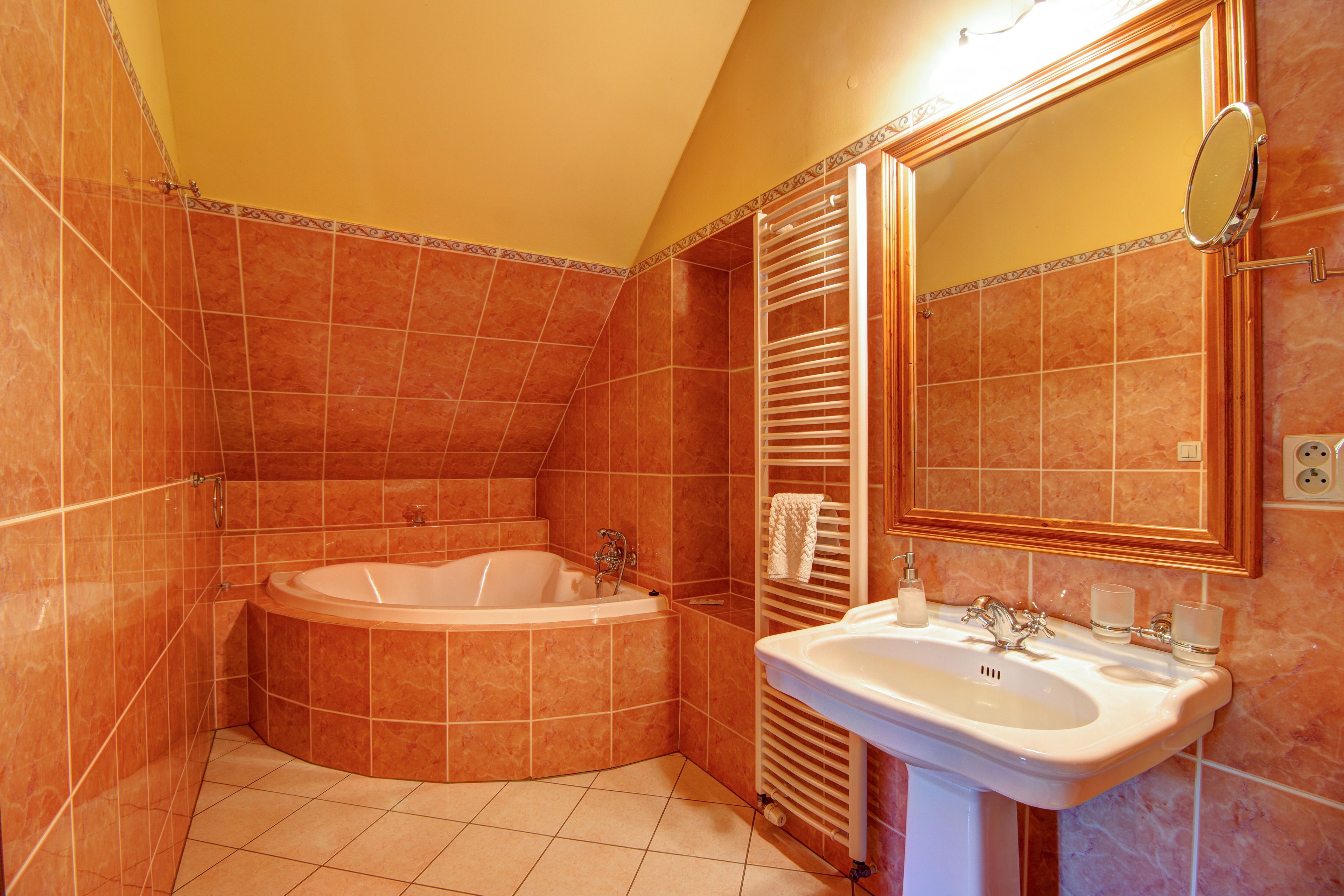 A bathroom with a bathtub, a sink, and a mirror.
