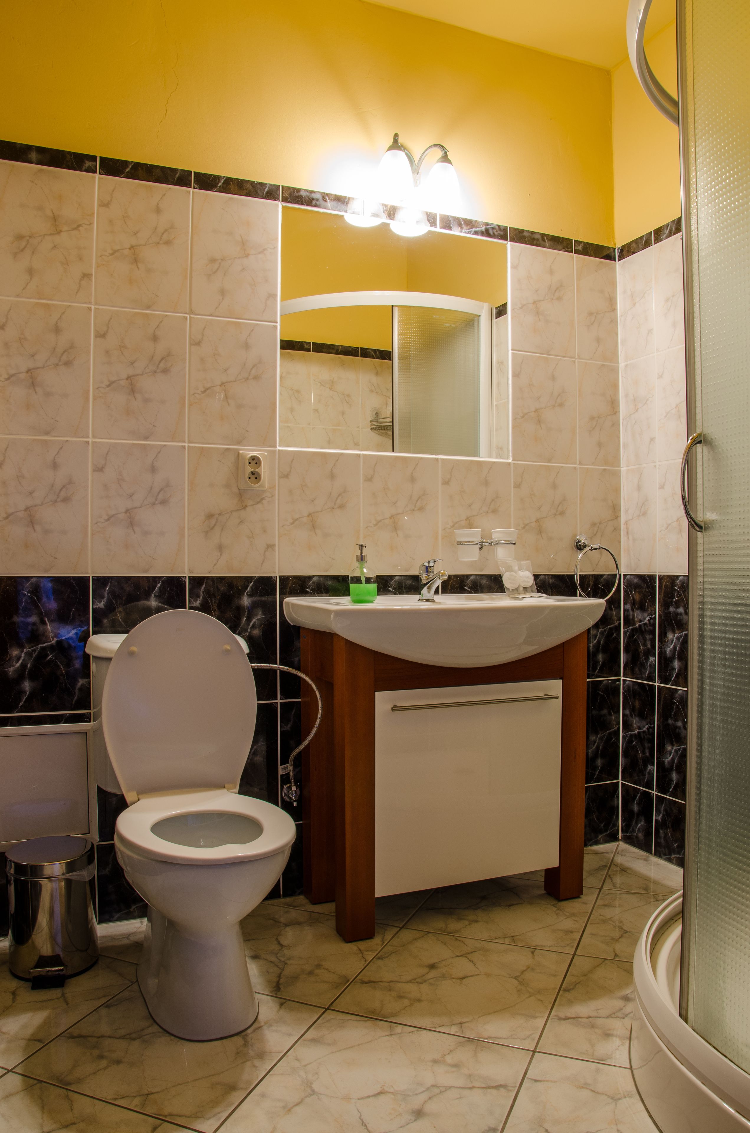 Un baño con inodoro, lavamanos y espejo.