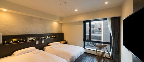 A hotel room with two beds, a desk, a chair, a TV, and a window with a city view.