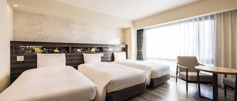 Ein Hotelzimmer mit zwei Betten, einem Schreibtisch und einem Stuhl.