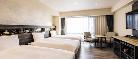 Habitación de hotel con dos camas, un escritorio, una silla, un televisor y un amplio ventanal con cortinas.