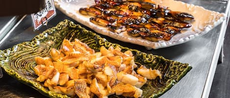 A buffet with various dishes including fried chicken, a baked dish, and a casserole.