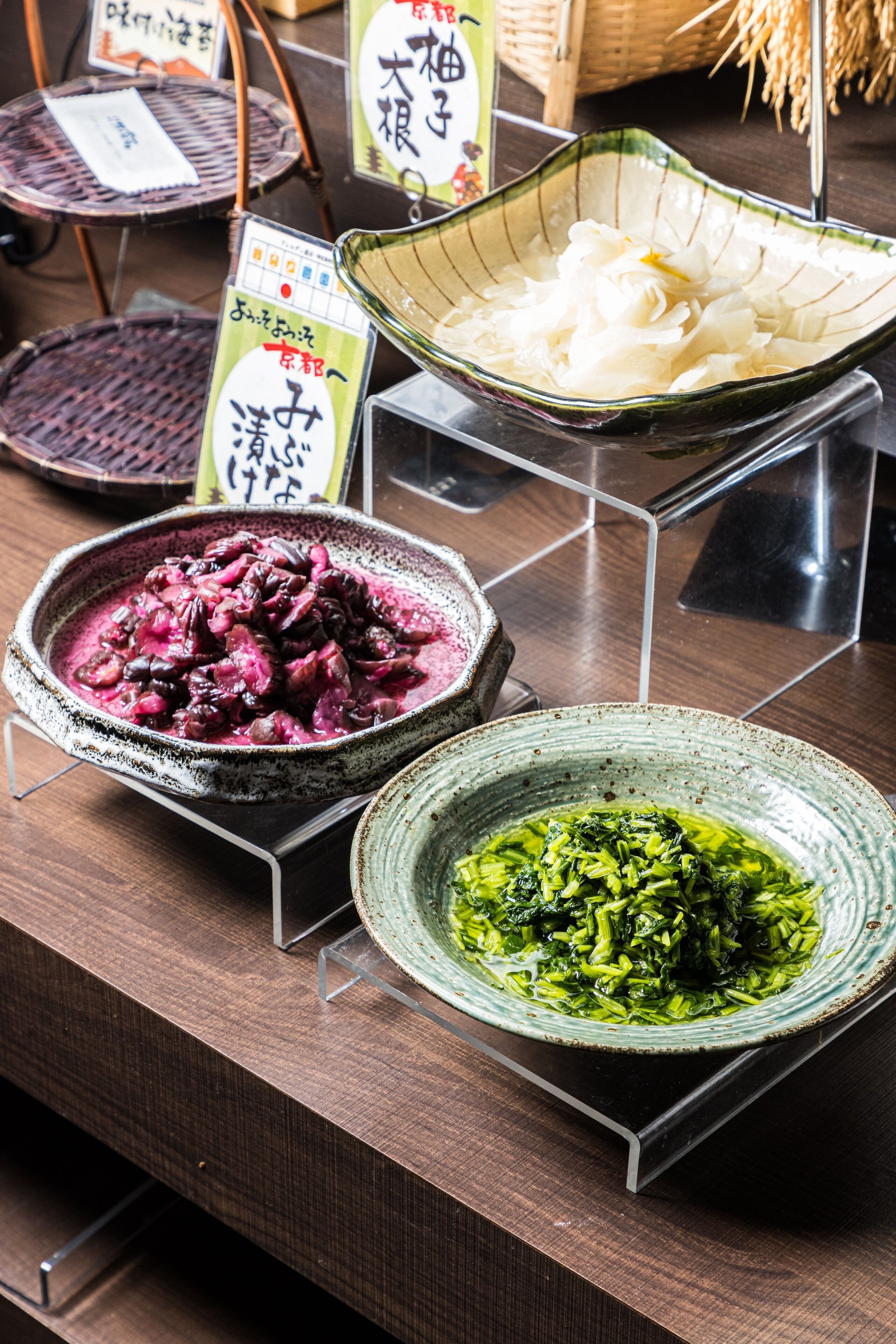 A display of various dishes in ceramic bowls on a wooden table.