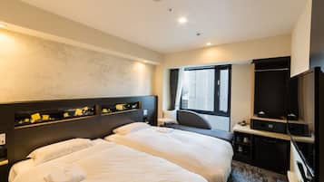 Habitación de hotel con dos camas, un escritorio, televisión y ventana.