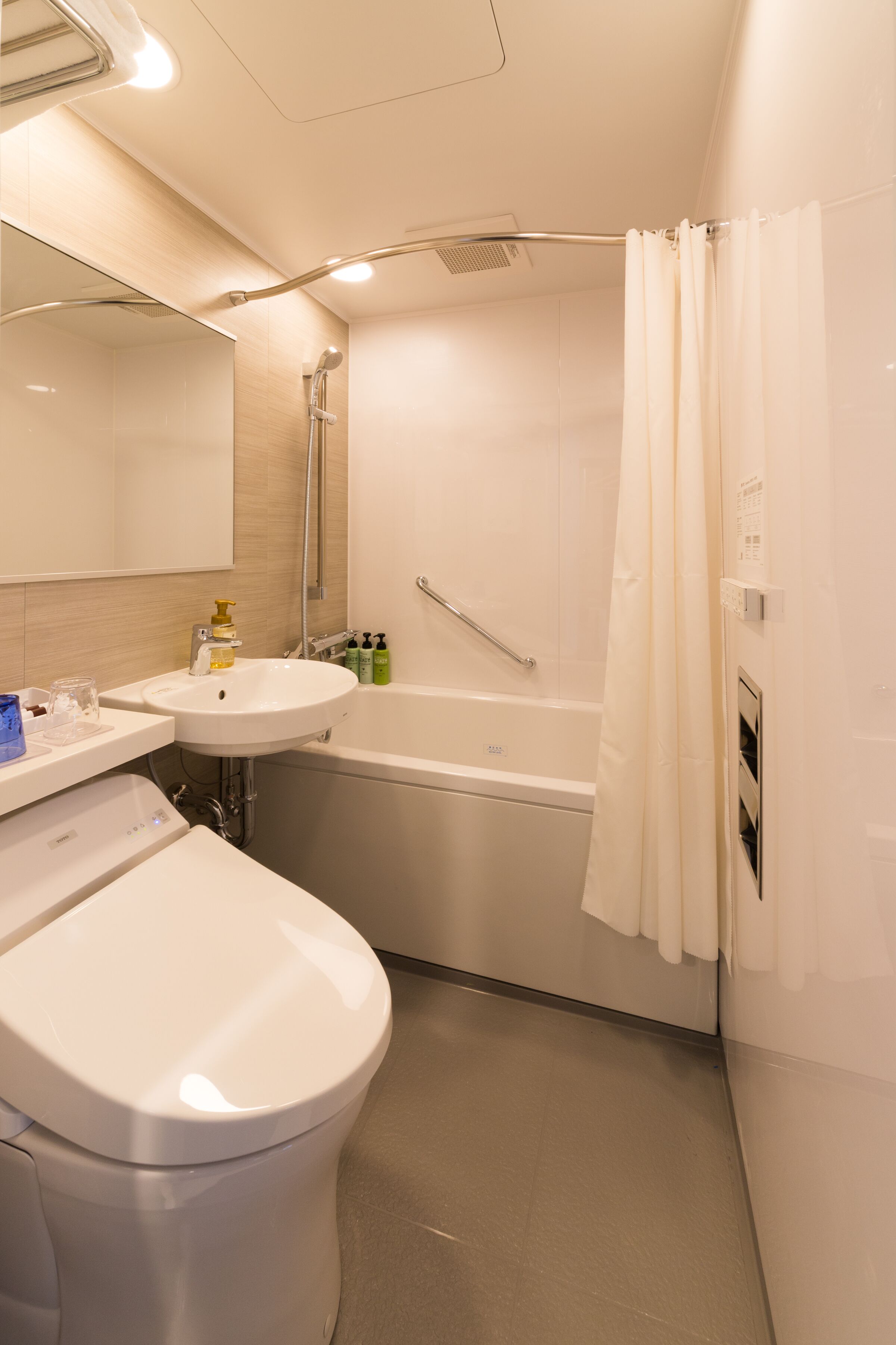 A modern bathroom with a toilet, sink, and bathtub.