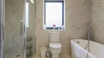 Un baño con inodoro, bañera y ducha.