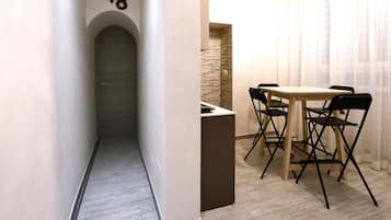 A hallway with a door marked '48', leading to a room with a table and chairs.