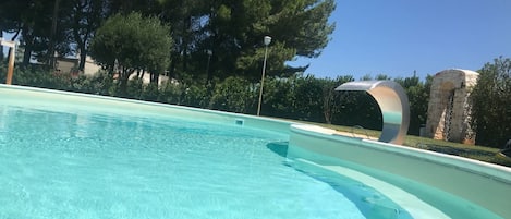 Una piscina al aire libre, sillones reclinables de piscina