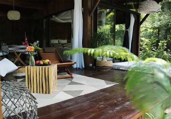 Une terrasse en bois avec une table à manger, des chaises et une petite plante.