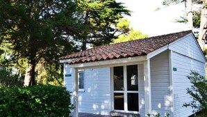 A small, single-story house with a tiled roof, white siding, and a front porch.