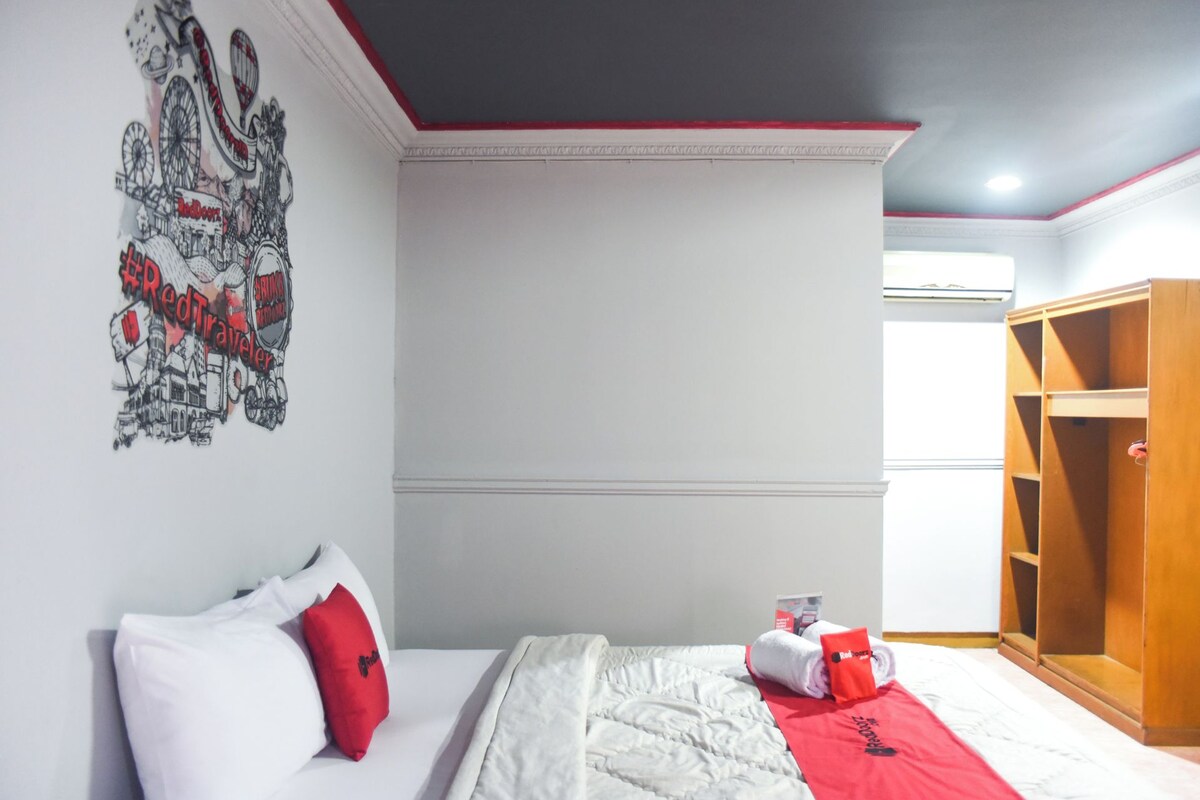 Une chambre d’hôtel avec un lit, une armoire et un mur orné d’une affiche sur le thème du voyage.
