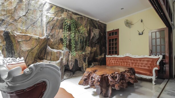 Une pièce avec un mur en pierre, une table basse en bois, un canapé et un fauteuil.