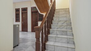 Un escalier avec des balustrades en bois et des marches en marbre menant à un palier.