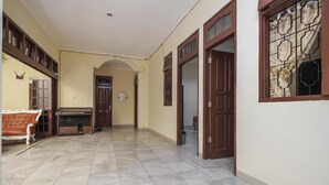 Un couloir avec un canapé, un radiateur et une porte donnant sur une autre pièce.