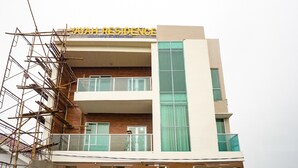 Un edificio de varios pisos con un letrero que dice "YAYAH RESIDENCE".