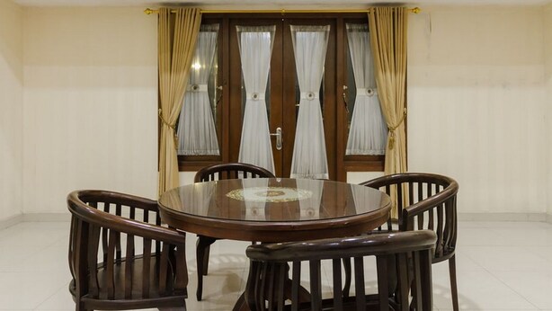 A dining area with a round wooden table and four chairs.