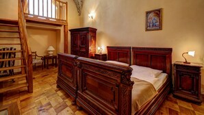 A traditional bedroom with a wooden four-poster bed, a wooden ladder, a desk, and a chair. - Penzión Cosmopolitan II. (Banska Stiavnica)