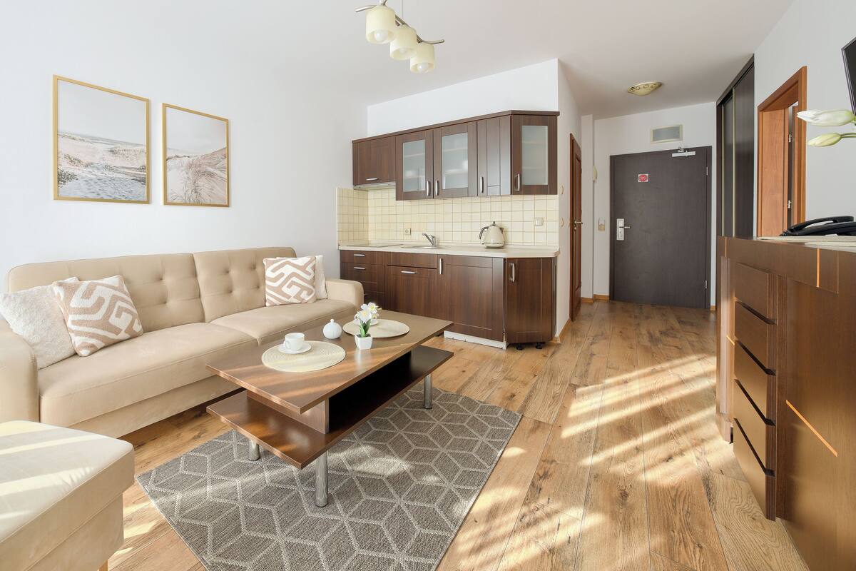 Una sala de estar moderna con sofá, mesa de centro y una obra de arte en la pared.