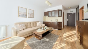 A modern living room with a sofa, coffee table, and artwork on the wall.