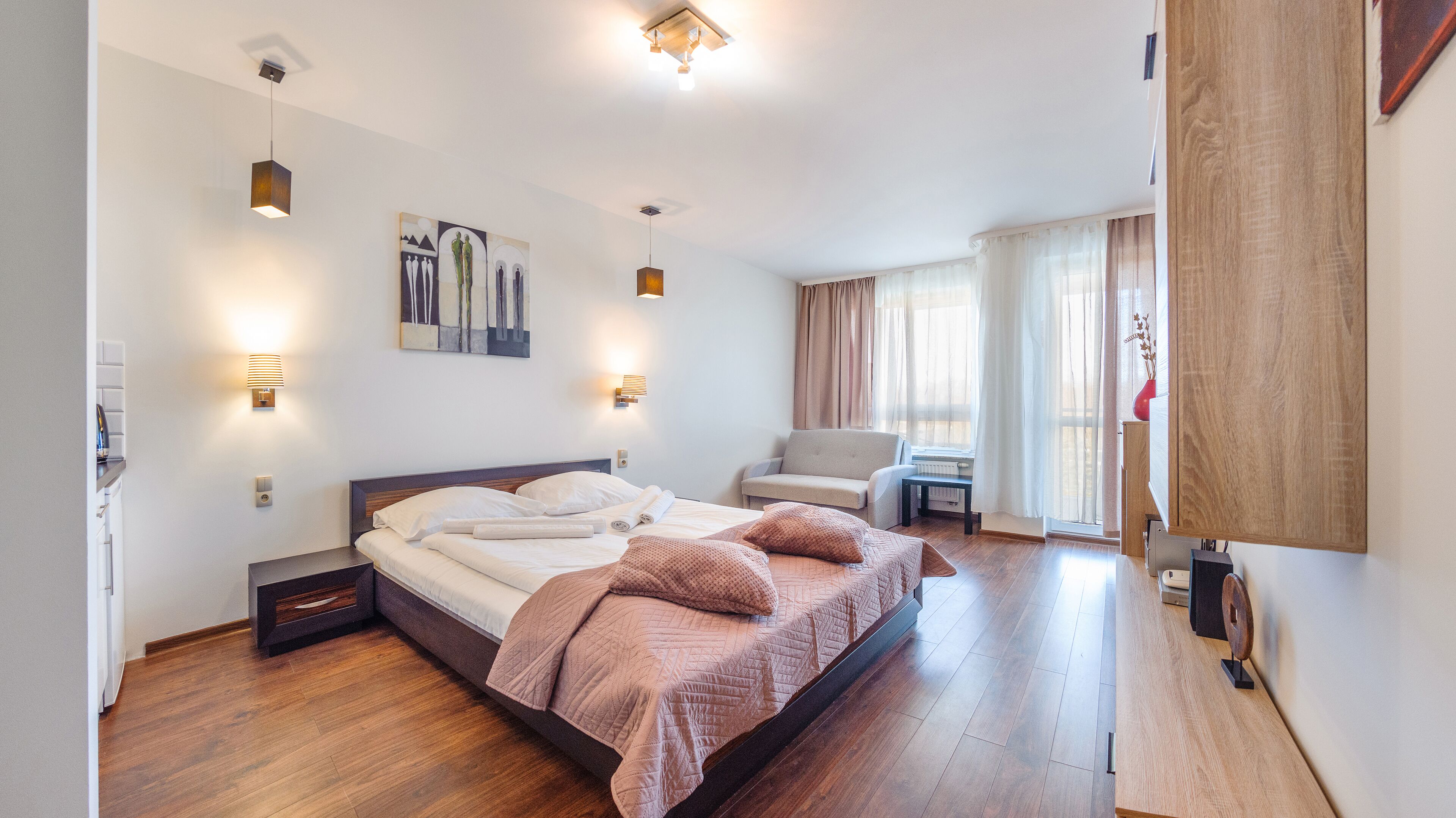 A modern bedroom with a large bed, a chair, and a desk.