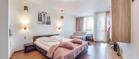A modern bedroom with a large bed, a chair, and a desk.
