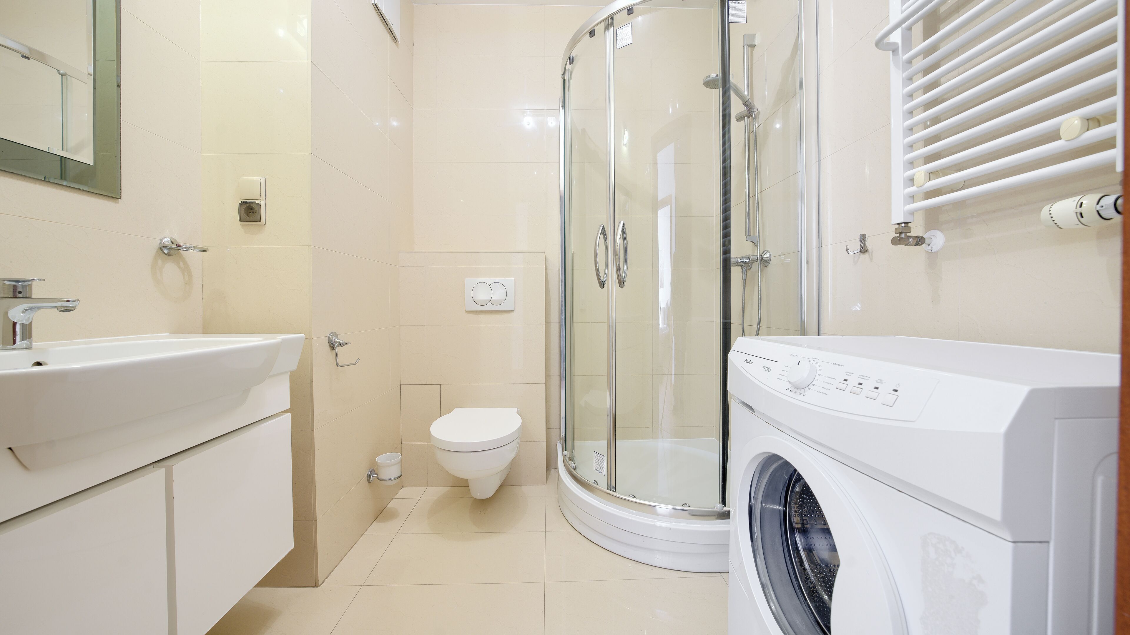 Un baño con lavabo, inodoro, ducha y lavadora.