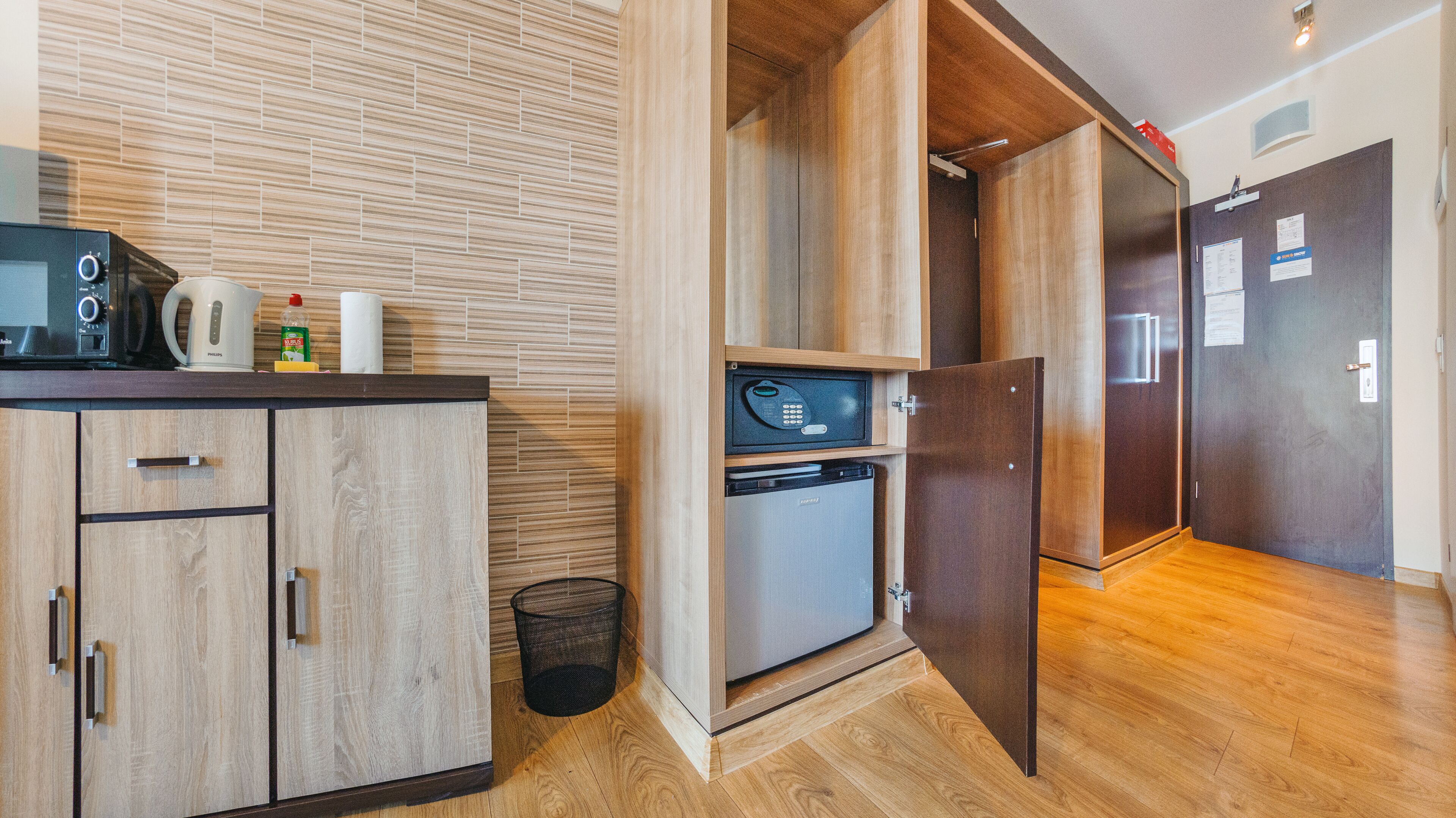 Una cocina moderna con armarios de madera, horno empotrado y cafetera.