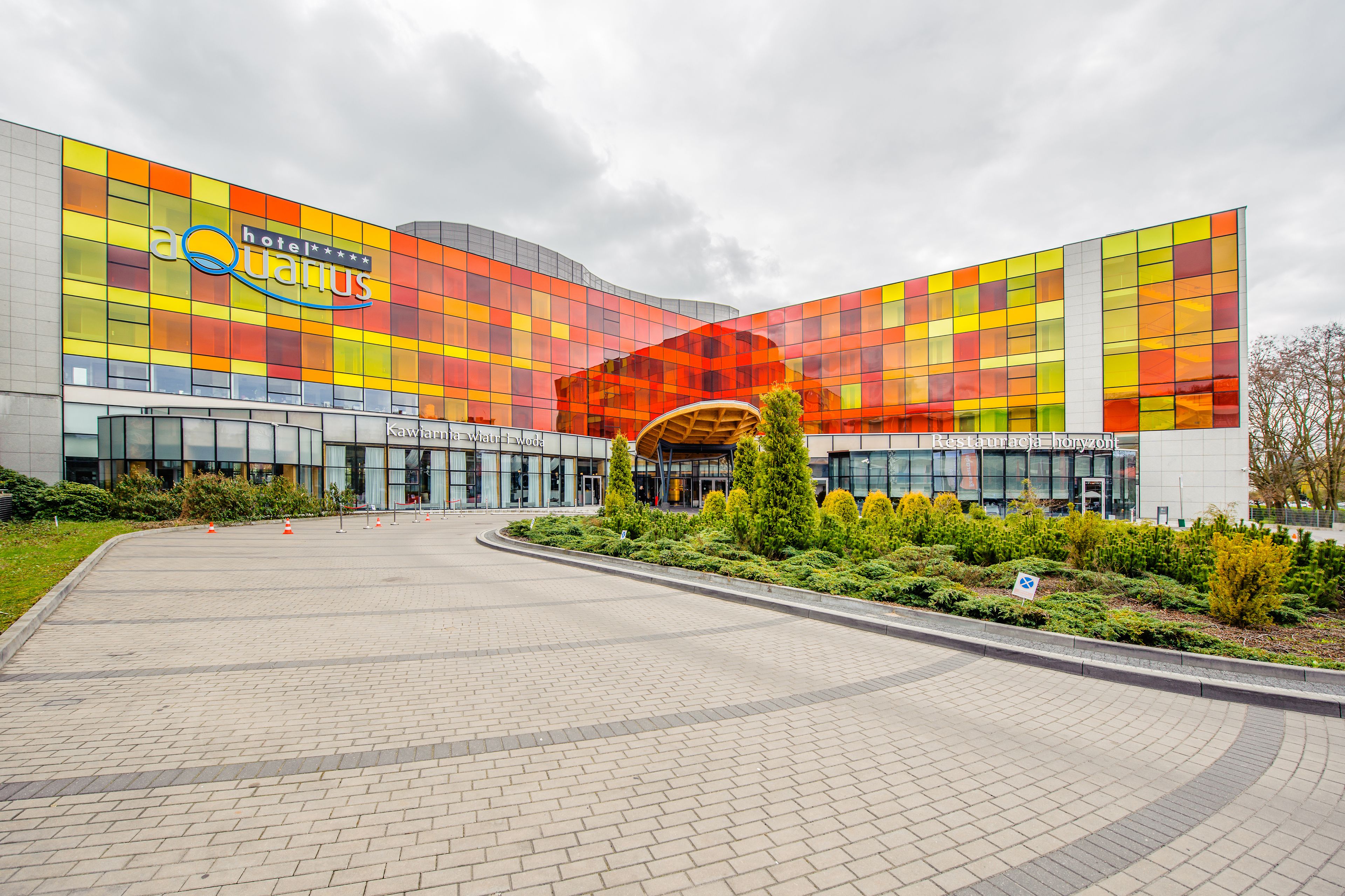 A modern hotel with a colorful facade and a central entrance.