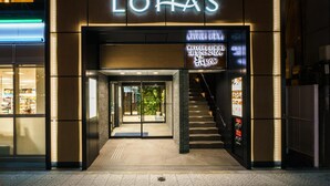 The entrance to a hotel with a modern design, featuring a prominent sign for 'Super Hotel Lohas' and a 'Wasyoku Dining' sign. - Super Hotel Premier Osaka Honmachi (Osaka)