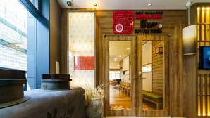 A hotel entrance with a wooden facade, a reception desk, and a seating area with chairs and tables. - Super Hotel Premier Osaka Honmachi (Osaka)