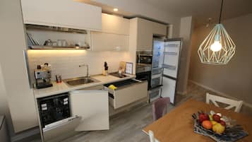 Departamento de lujo, balcón, vista a la ciudad | Cocina privada | Refrigerador con congelador, microondas, horno y parrilla de estufa 