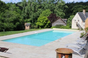Una piscina al aire libre de temporada, tumbonas