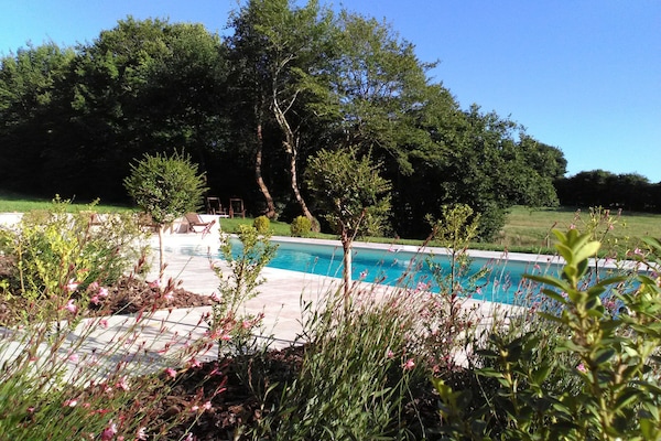 Una piscina al aire libre de temporada, tumbonas
