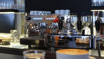 A bar area with a sign reading "Lobby Bar," espresso machines, and a cup of coffee on a tray.