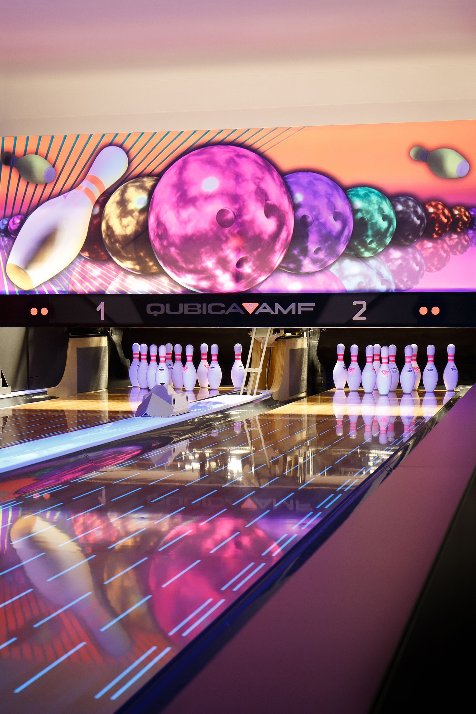 A bowling alley with a neon sign and a scoreboard.
