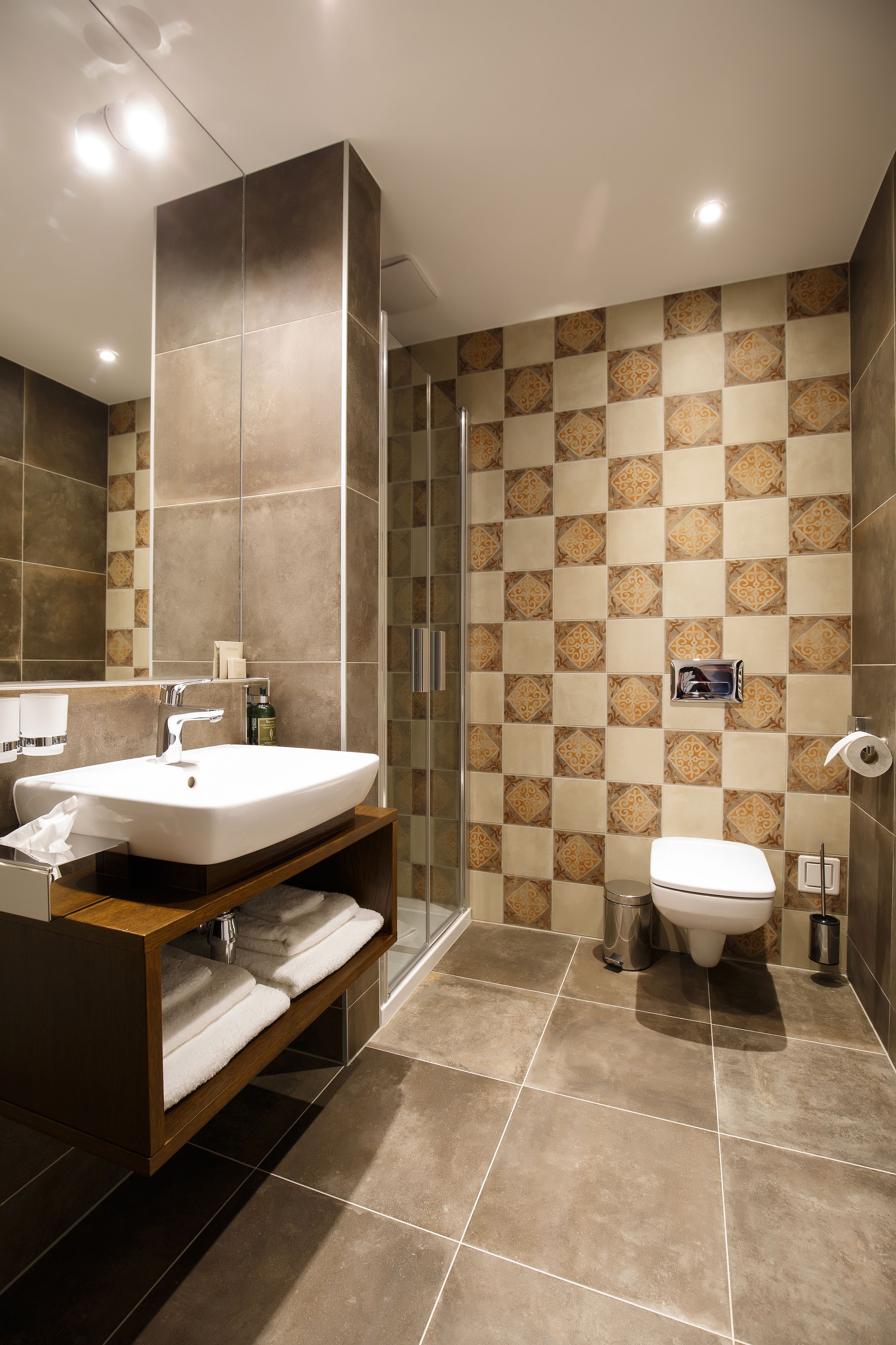 Un baño moderno con un lavamanos grande, espejo y zona de ducha.