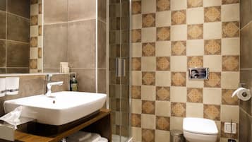 Un baño moderno con un lavamanos grande, espejo y zona de ducha.