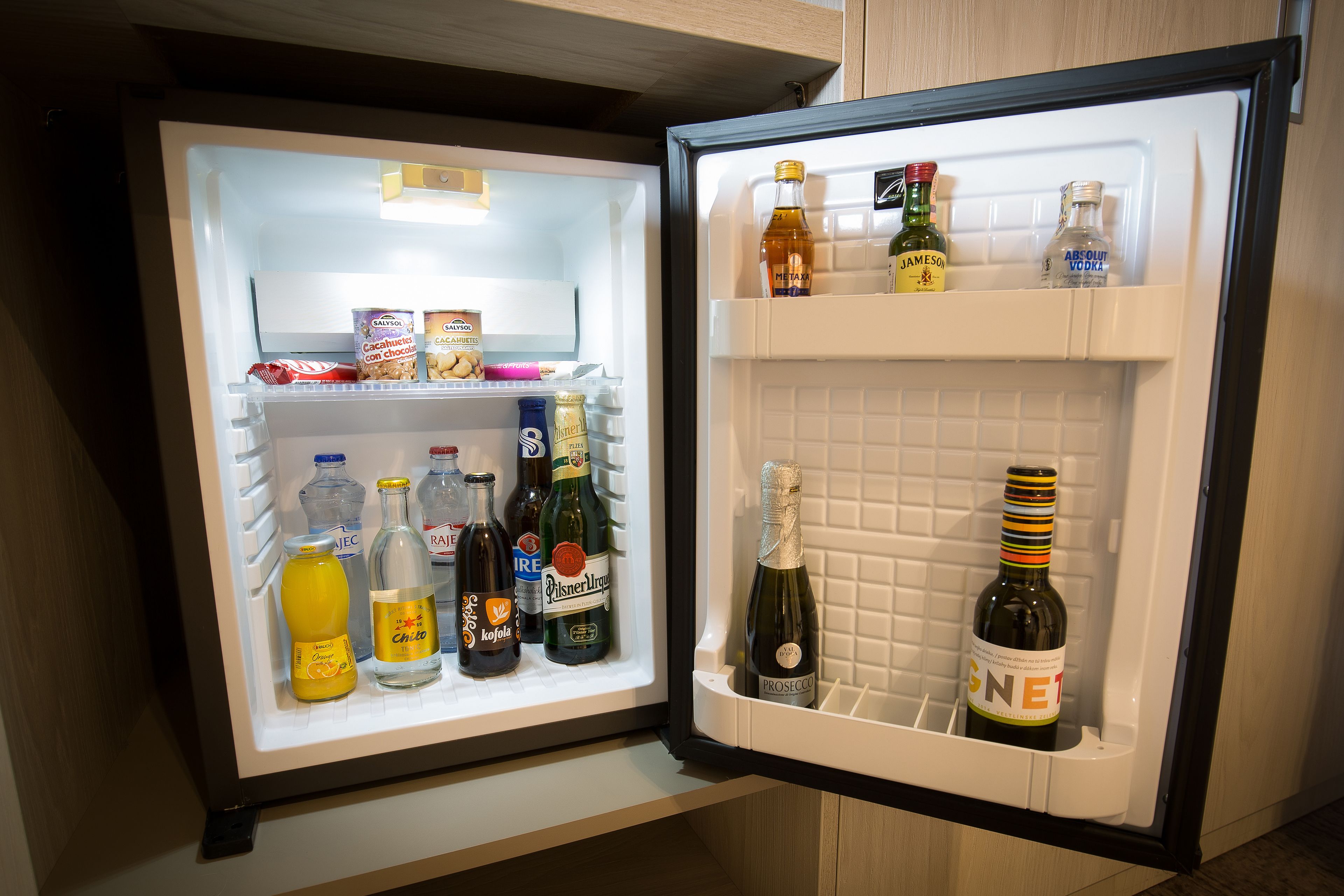 Un réfrigérateur doté de plusieurs étagères contenant diverses boissons et denrées alimentaires.