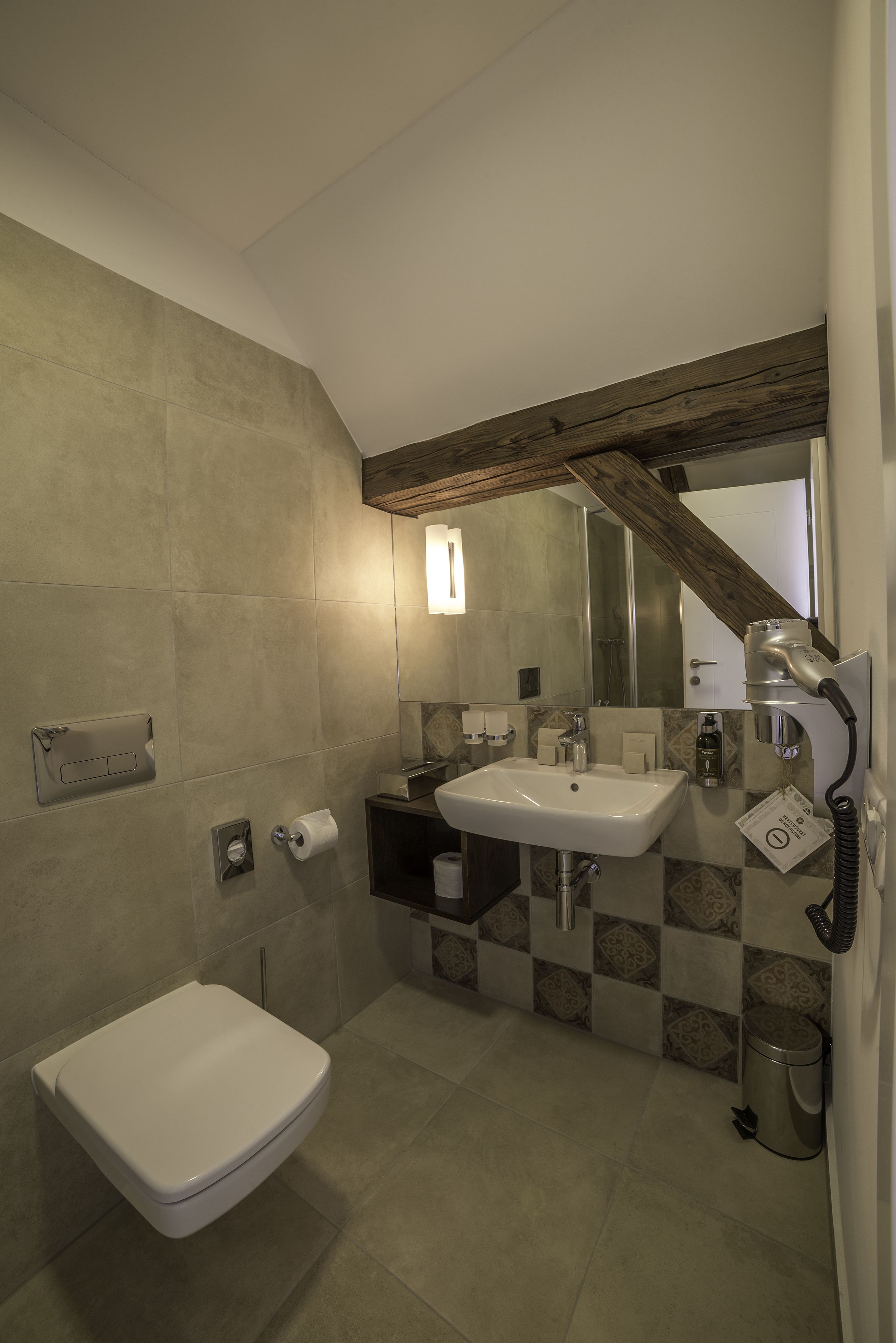 A bathroom with a toilet, sink, and shower area.
