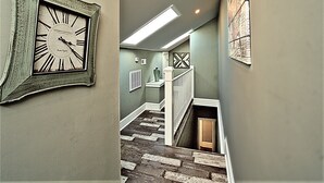 A staircase with a clock on the wall, a radiator, and a vase on a shelf. - Downtown Savannah Oasis 4 BR 3 BA (Savannah)