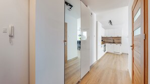 Une cuisine moderne avec des armoires blanches, un pare-feu en bois et un robinet noir.