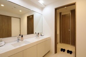 A modern bathroom with a large mirror, two sinks, and a wooden door. - GRAND HOSTEL LDK Osaka Shinsaibashi (Osaka)