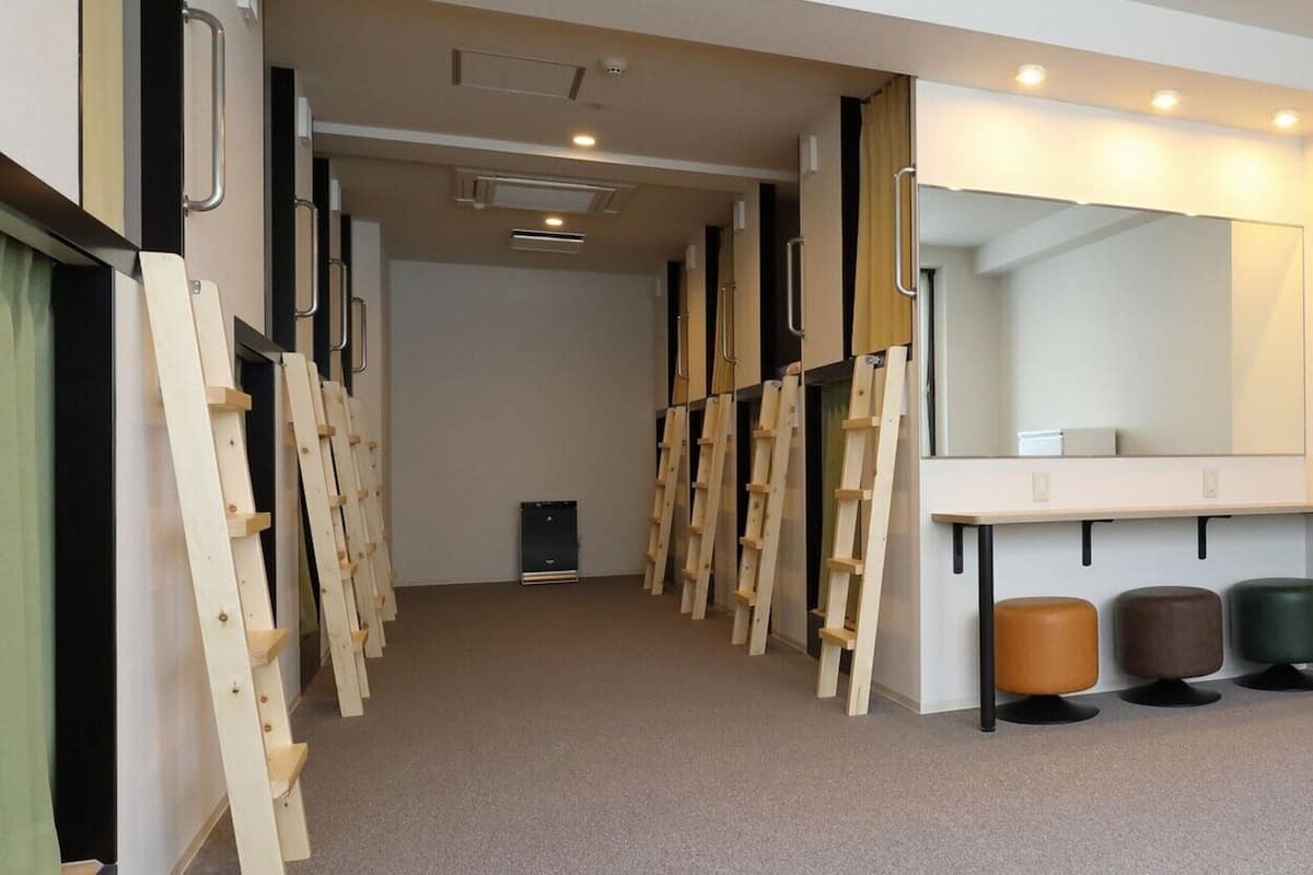 A corridor with wooden ladders, a mirror, and a bench.